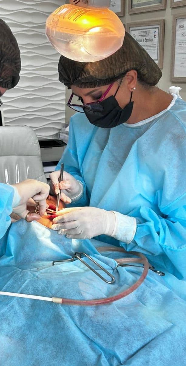 Dra. Michele Herreira durante cirurgia de implante dentário no consultório em Suzano
