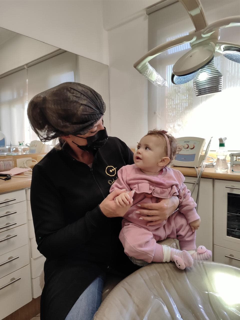Dra. Michele Herreira atendendo um bebê no consultório, em Suzano
